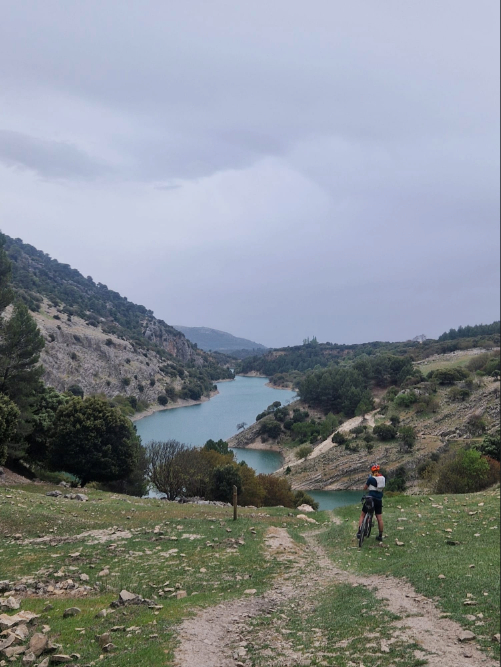 Julie sur son vélo, sur un chemin surplombant un like, en Espagne.